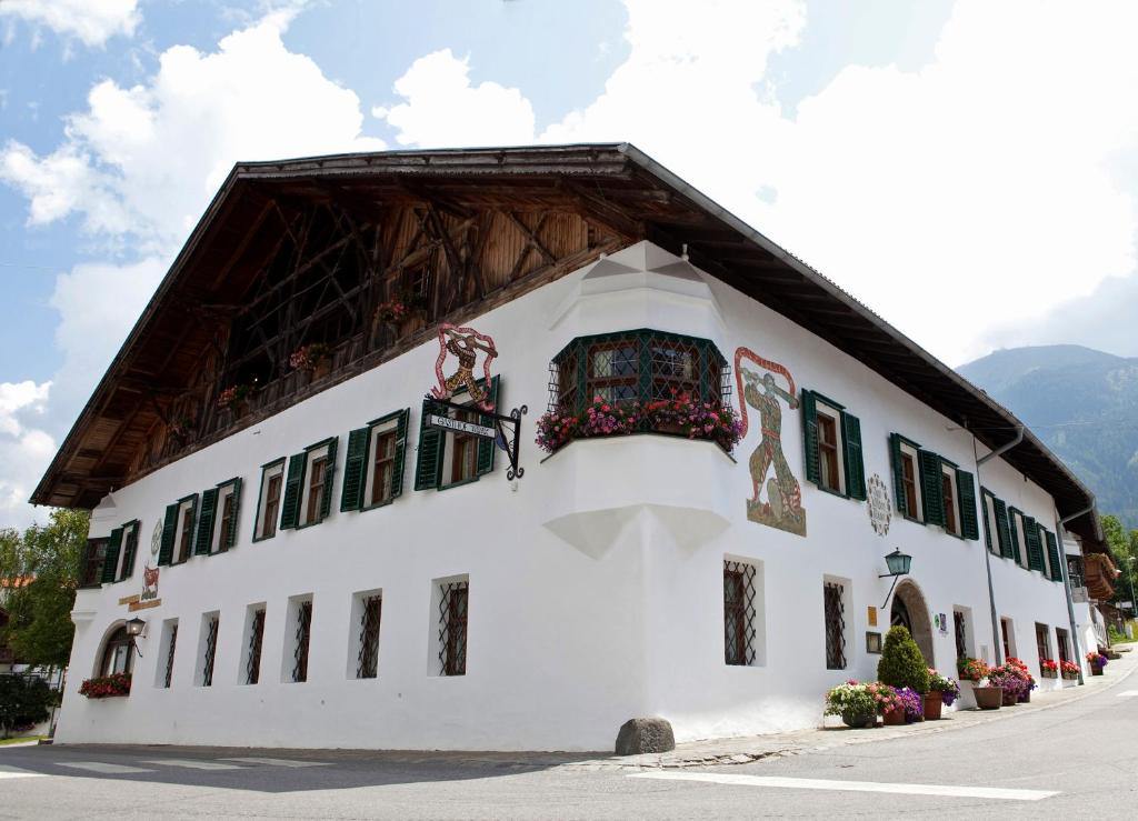 um edifício branco com um telhado de gambrel em Landgasthof "Wilder Mann" em Innsbruck