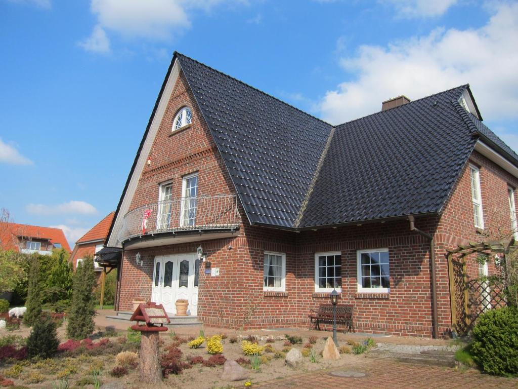 une maison en briques rouges avec un toit noir dans l'établissement Hotel Heidetraum, à Schneverdingen