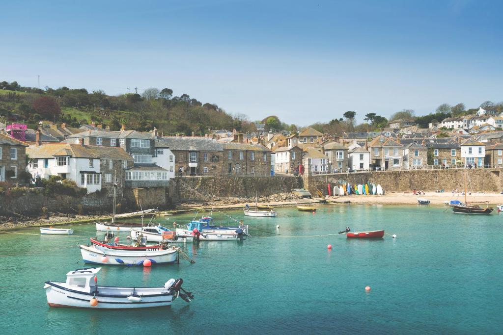 un gruppo di imbarcazioni in una cassa d’acqua con case di The Ship Inn a Mousehole