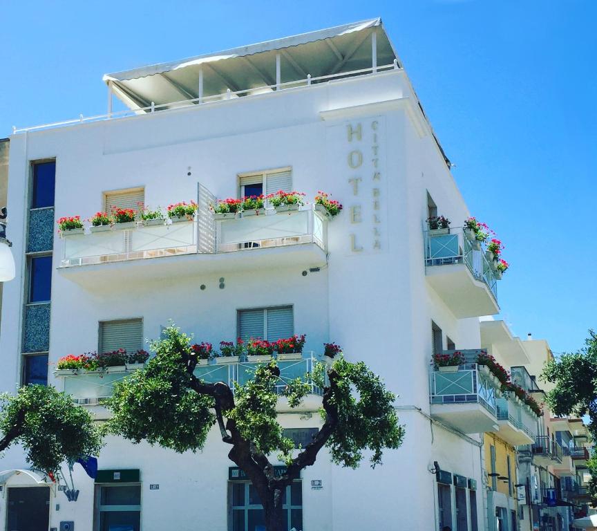 ein weißes Gebäude mit Blumenkästen auf den Balkonen in der Unterkunft Hotel Città Bella in Gallipoli