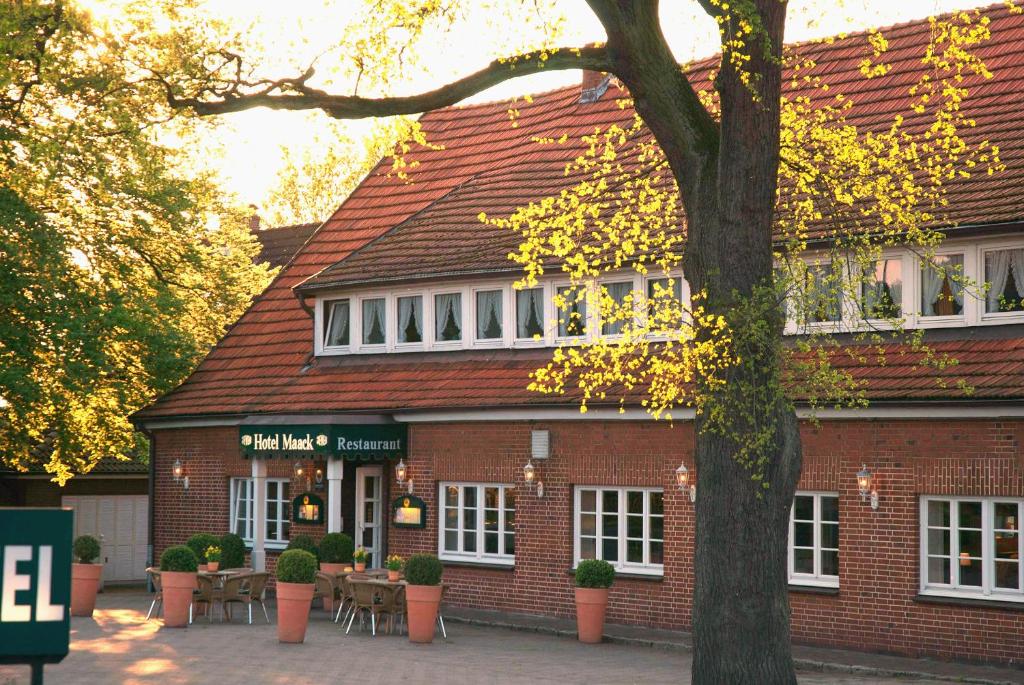 a brick building with a tree in front of it at Hotel Maack in Seevetal