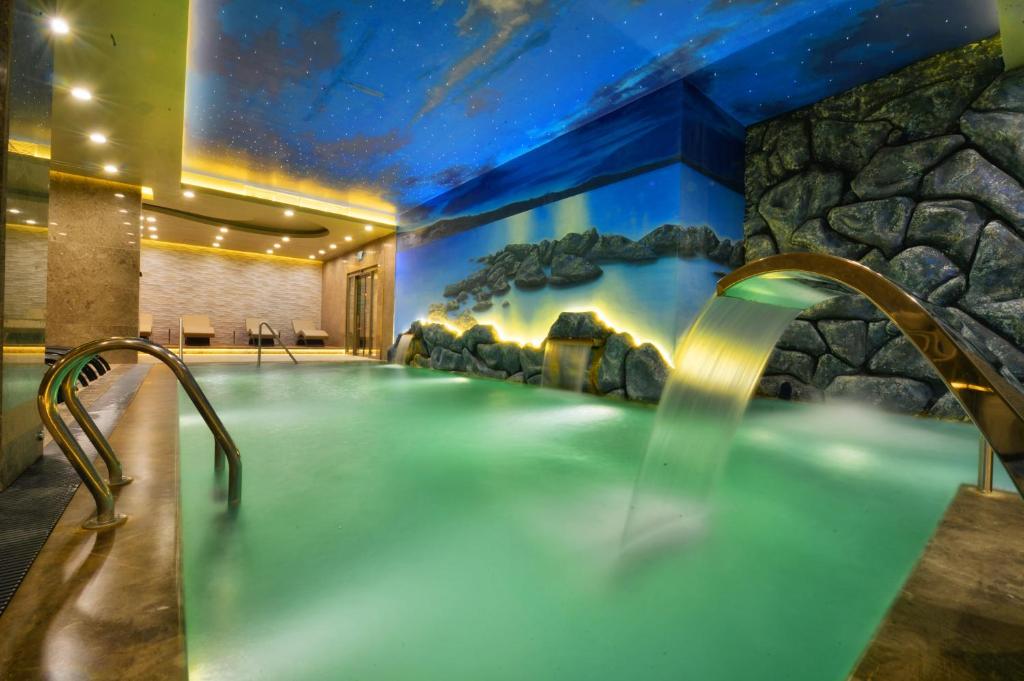 a hot tub in a room with a stone wall at Marigold Thermal & Spa Hotel Bursa in Bursa