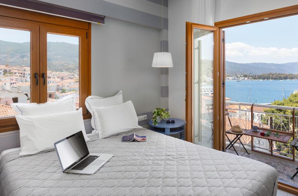 um quarto com uma cama com um computador portátil em Dimitra Boutique Hotel em Poros