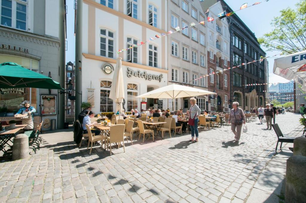 漢堡的住宿－Appartements in der historischen Deichstrasse contactless Check in，坐在街上桌子上的一群人