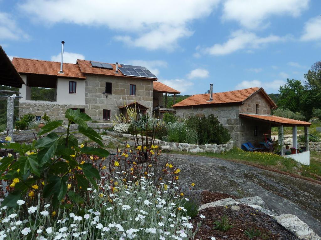 une maison avec des panneaux solaires sur le toit dans l'établissement Quinta do Cobral, à Oliveira do Hospital