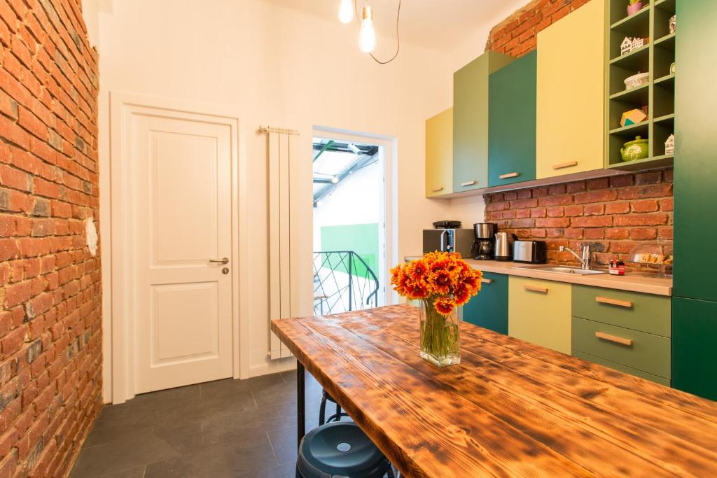 een keuken met een houten tafel en een vaas met bloemen erop bij First Hostel in Boekarest