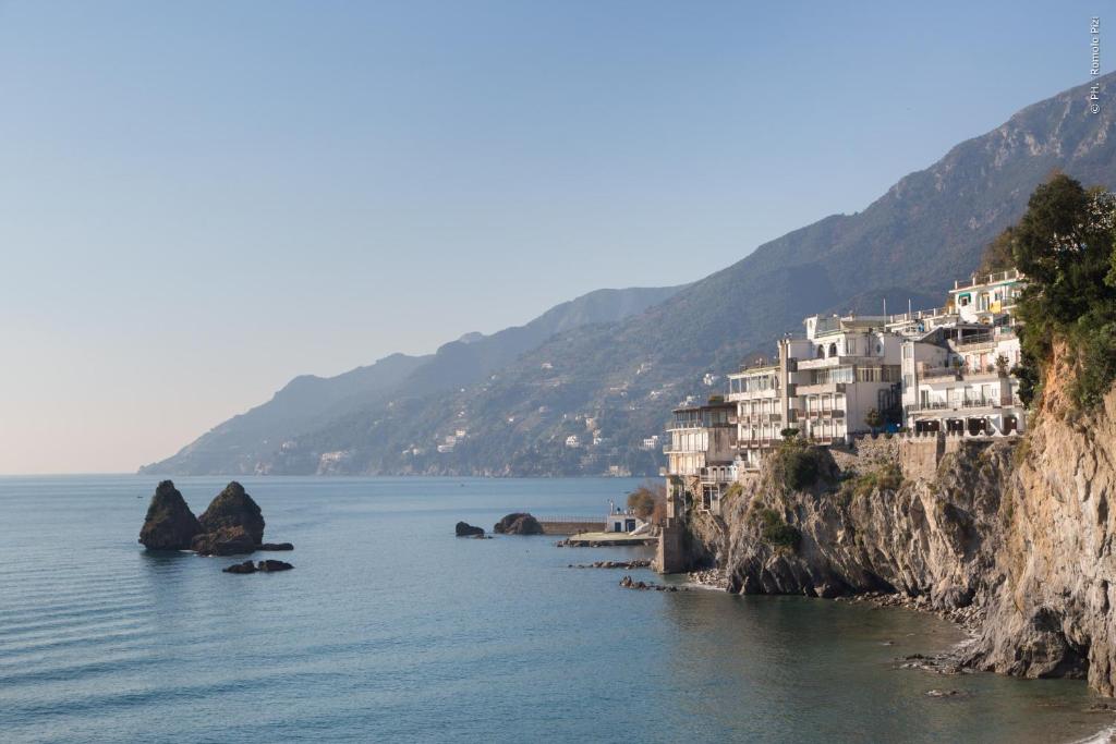 un gruppo di case su una collina vicino all'acqua di Hotel La Lucertola a Vietri