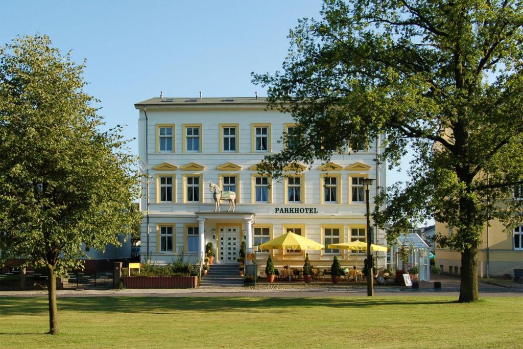 um edifício branco com mesas à frente em Parkhotel del Mar em Sassnitz