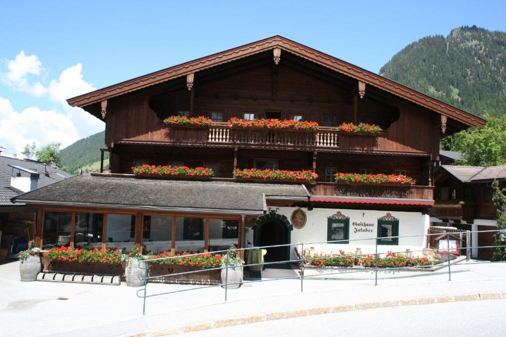 un edificio con flores a un lado. en Gasthaus Jakober, en Alpbach