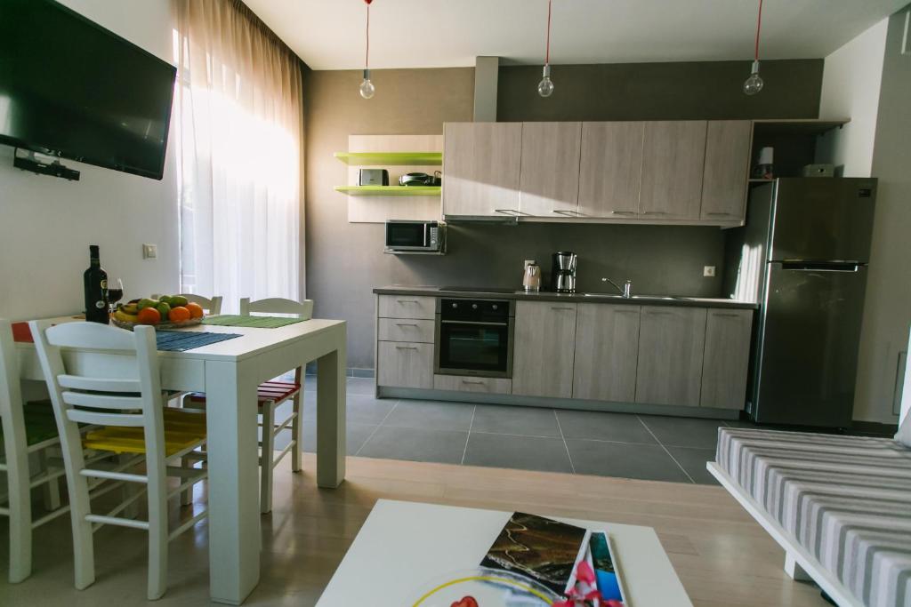 cocina con mesa, nevera y armarios en Maistros Kardamyli Apartments, en Kardhamili