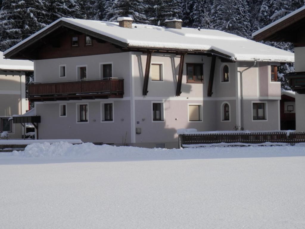 uma casa branca com um telhado coberto de neve em Appartement Nischler em Wald im Pinzgau