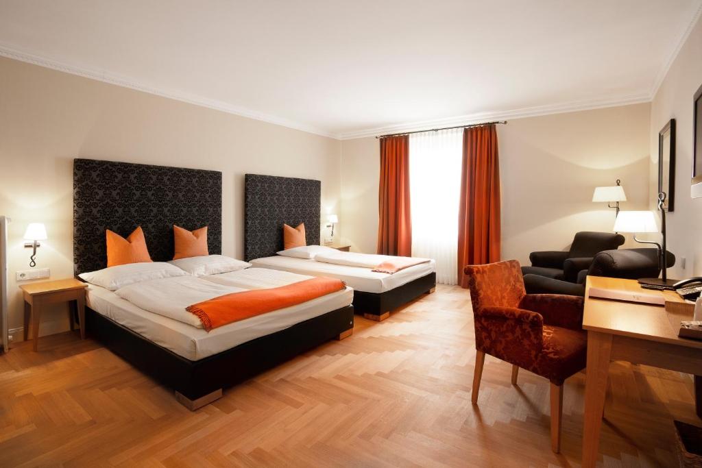 a hotel room with two beds and a desk at Hotel Villa Florentina in Frankfurt/Main