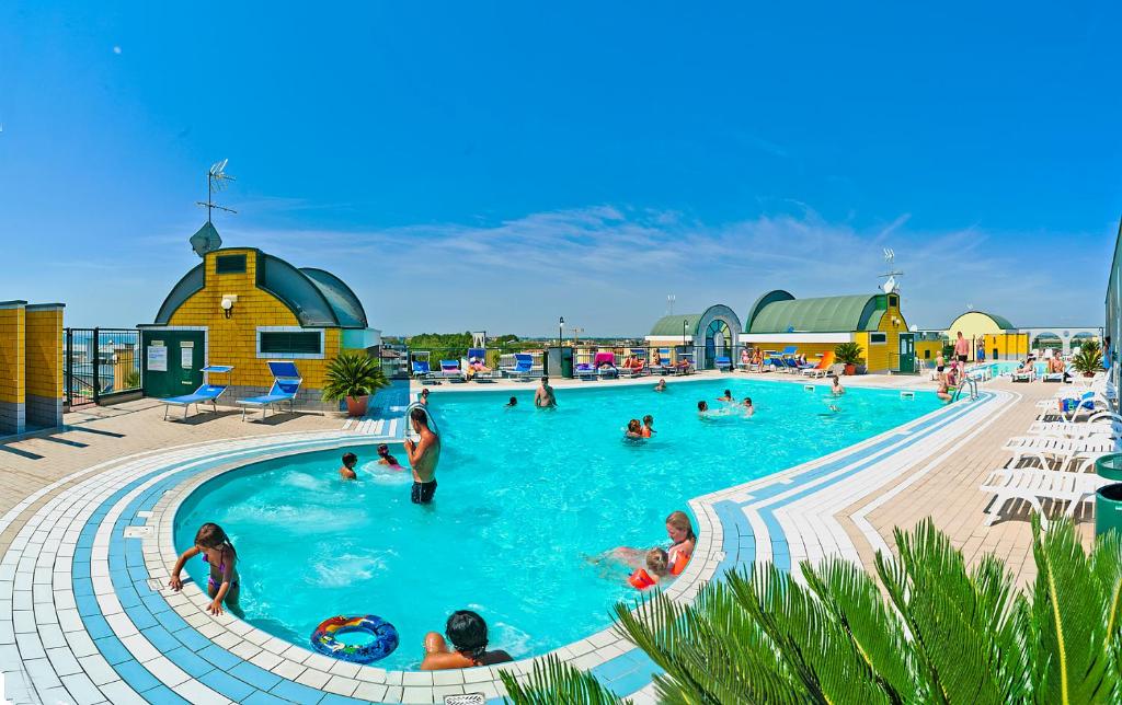 eine Gruppe von Personen in einem Pool in einem Resort in der Unterkunft Residence Cristoforo Colombo in Caorle