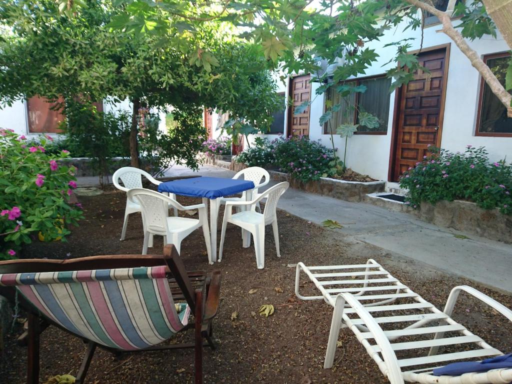 a table and chairs and a blue table and chairs at Hostal Darwin B&B in Puerto Ayora