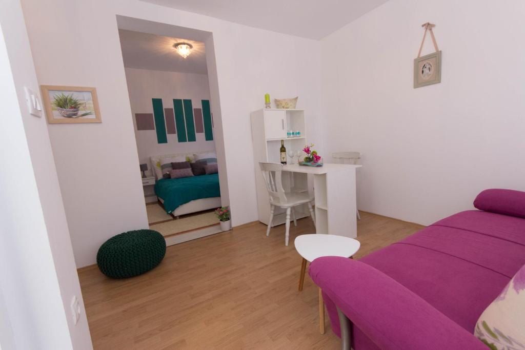 - un salon avec un canapé violet et une table dans l'établissement Apartments Kruno, à Međugorje