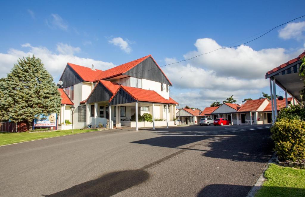 een rij huizen met rode daken op een straat bij Bennetts Thermal Motor Inn in Tauranga