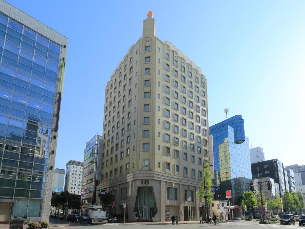 un edificio alto en medio de una ciudad en Hotel Monterey La Soeur Fukuoka, en Fukuoka