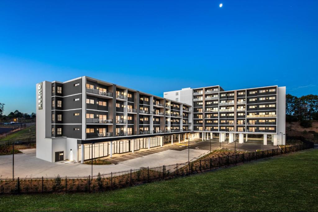 een groot appartementencomplex met verlichting aan bij Quest Bella Vista in Baulkham Hills