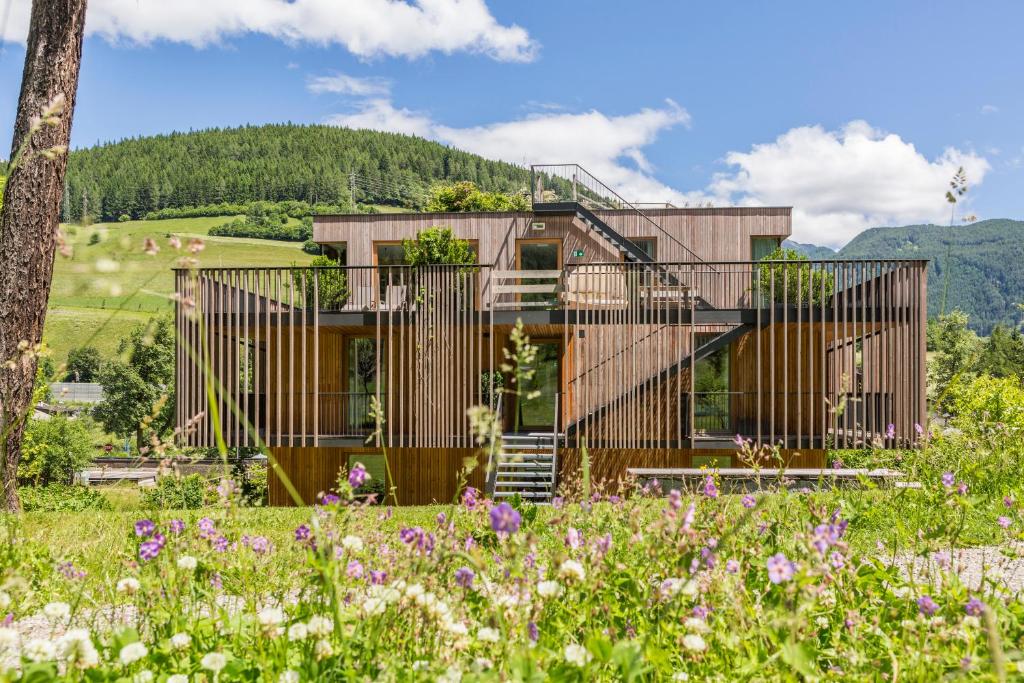 uma casa nas montanhas com um jardim em Steindl's Boutique Hotel em Vipiteno