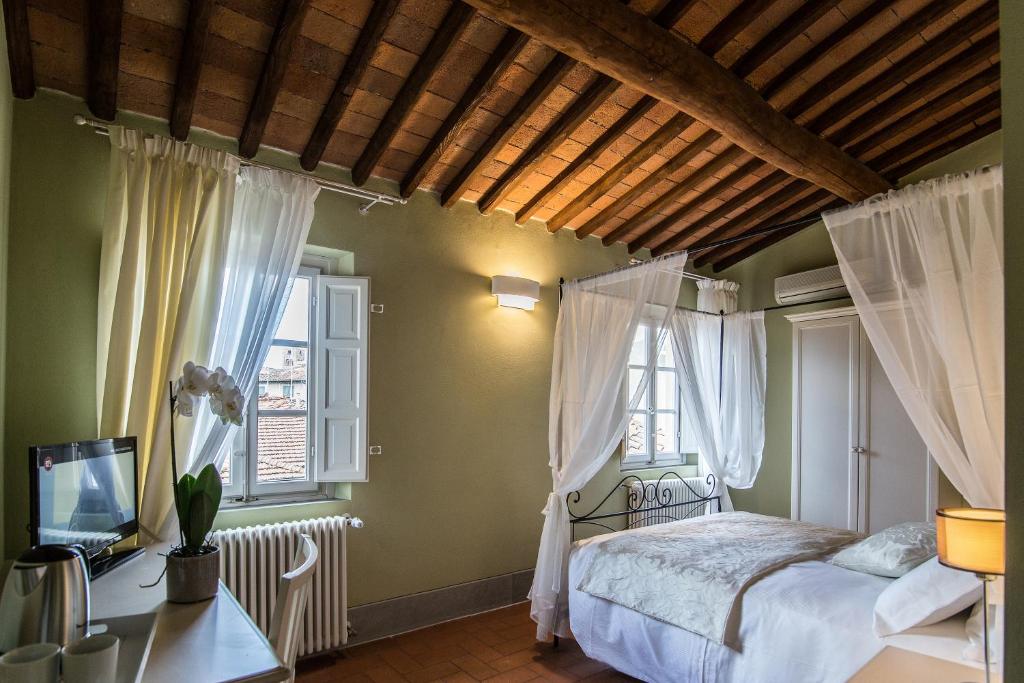 een slaapkamer met een bed en 2 ramen bij B&B Residenza Di Via Fontana in Lucca