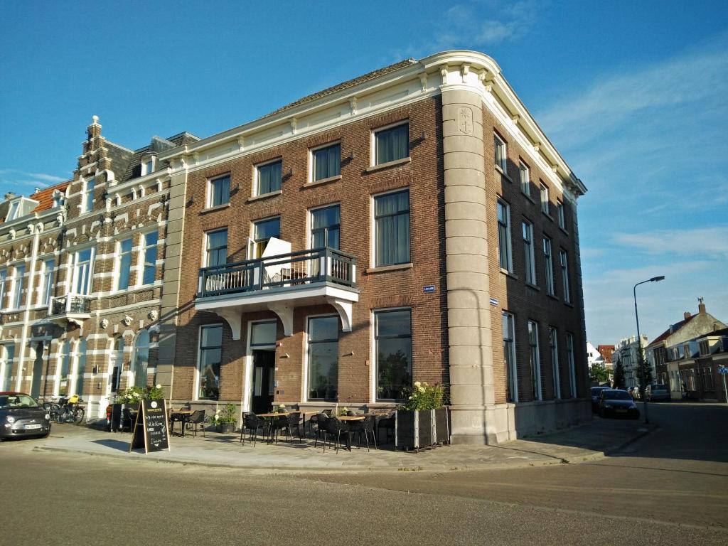 een groot bakstenen gebouw op de hoek van een straat bij Hotel Loskade 45 in Middelburg