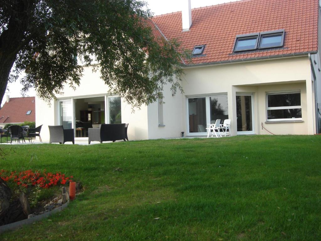 uma casa com um quintal com relva verde em Chambres d'Hôtes La Villa des Hortensias em Berck-sur-Mer