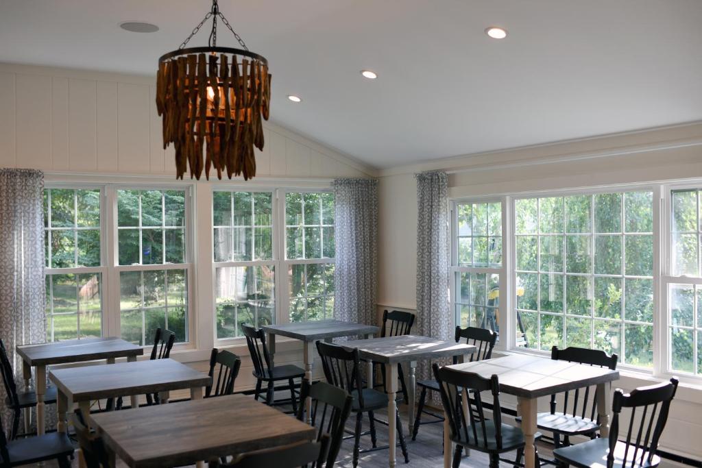 a dining room with tables and chairs and windows at Sandwich Inn and Suites in Sandwich