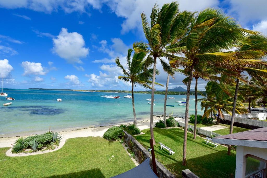 uma vista para a praia a partir da varanda de um resort em Turquoise Bay Beach Apartments Trou d'Eau Douce em Trou dʼ Eau Douce