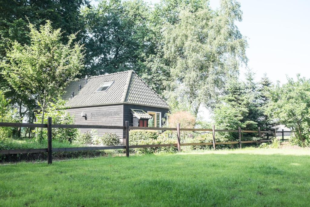 ein Holzzaun vor einem Haus in der Unterkunft Gastenverblijf Het Muzehuis in Dalfsen