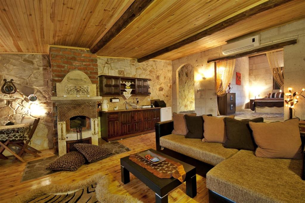 a living room with a couch and a fireplace at Adanos Konuk Evi in Avanos