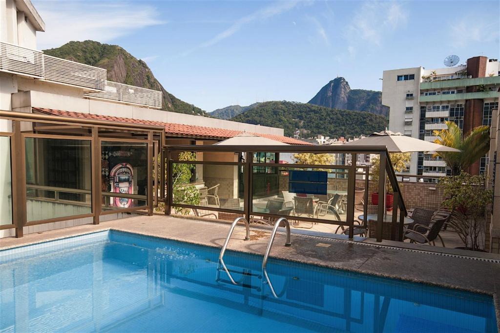 una piscina con sombrilla junto a un edificio en Mar Palace Copacabana Hotel, en Río de Janeiro