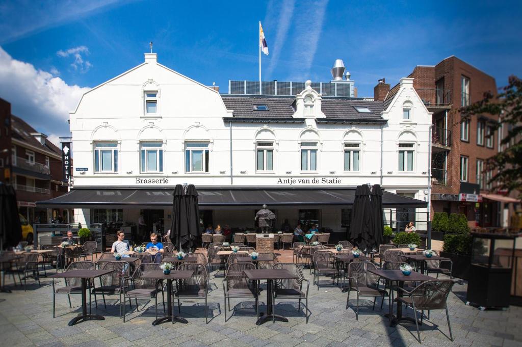 eine Gruppe von Tischen und Stühlen vor einem Gebäude in der Unterkunft Brasserie-Hotel Antje van de Statie in Weert