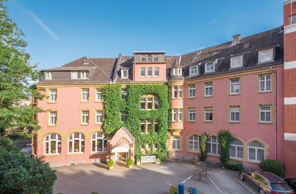 un grande edificio con edera sul lato di Hotel Oranien Wiesbaden a Wiesbaden