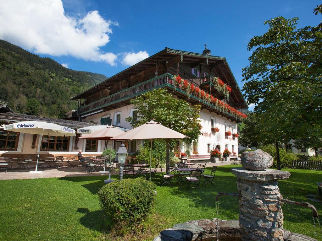 un grand bâtiment avec des fleurs sur son côté dans l'établissement Hotel Senningerbräu, à Bramberg am Wildkogel