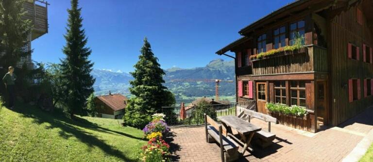 una panchina seduta di fronte a un edificio di Appartement Fernsicht Triesenberg a Triesenberg