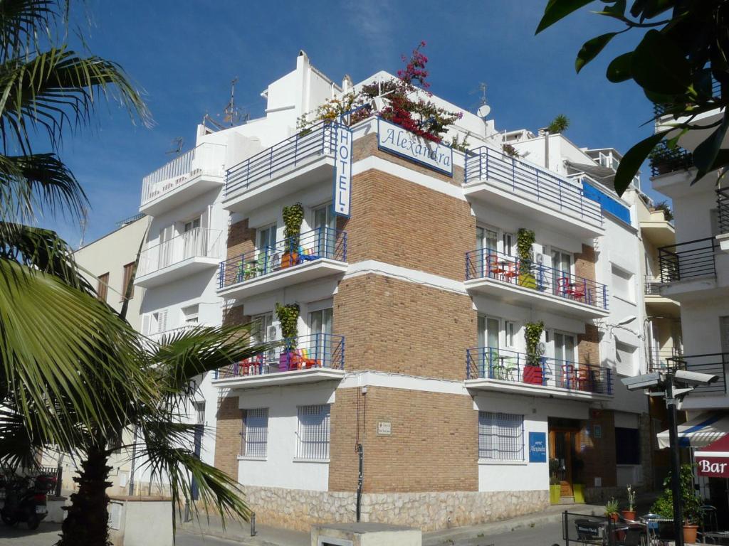 um edifício com flores nas varandas em Hotel Alexandra Sitges em Sitges