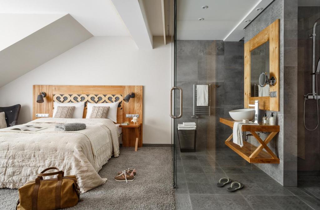 een slaapkamer met een bed, een douche en een wastafel bij Villa Nova in Zakopane