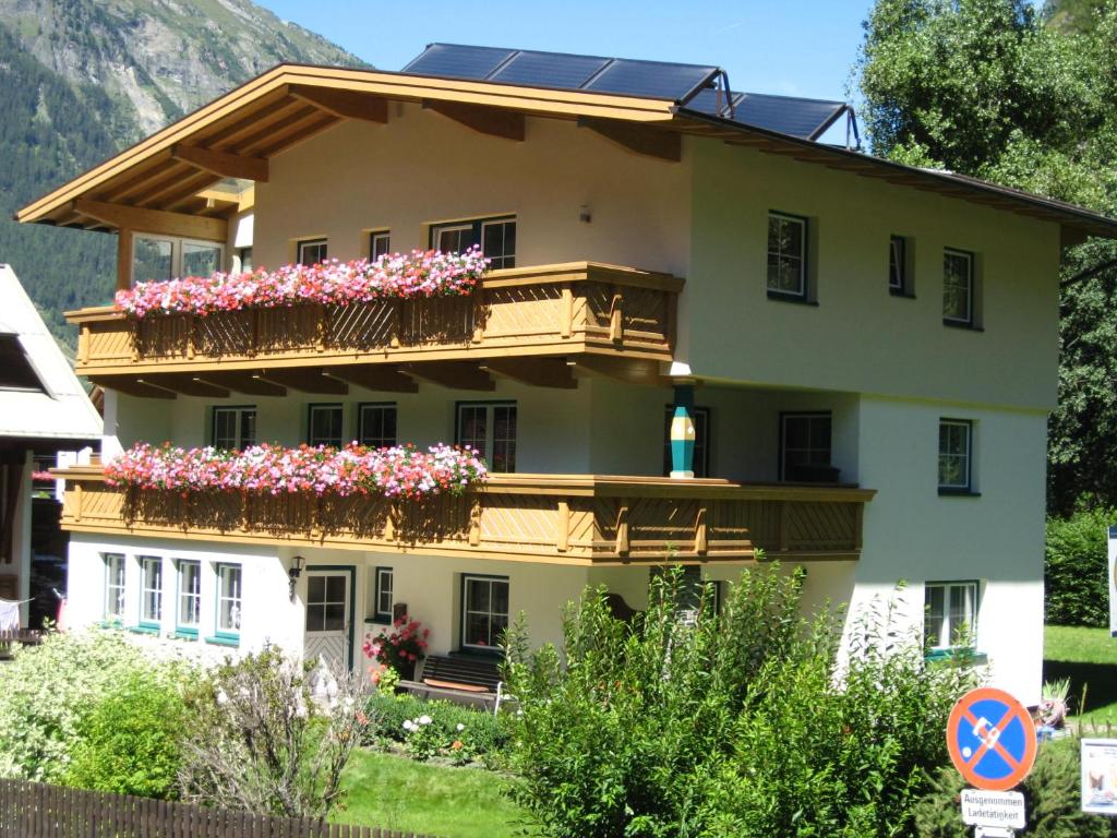 a building with flowers on the balconies of it at Haus Kristall in Längenfeld