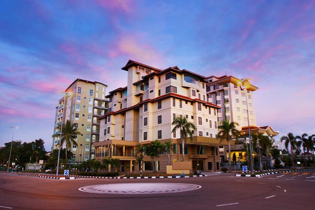 um grande edifício com palmeiras em frente a uma rua em D'Anggerek Serviced Apartment em Bandar Seri Begawan