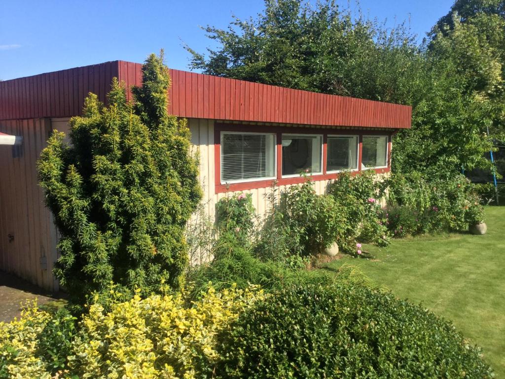 une maison avec un toit rouge et quelques buissons dans l'établissement Risskov Bellevue Guesthouse, à Aarhus