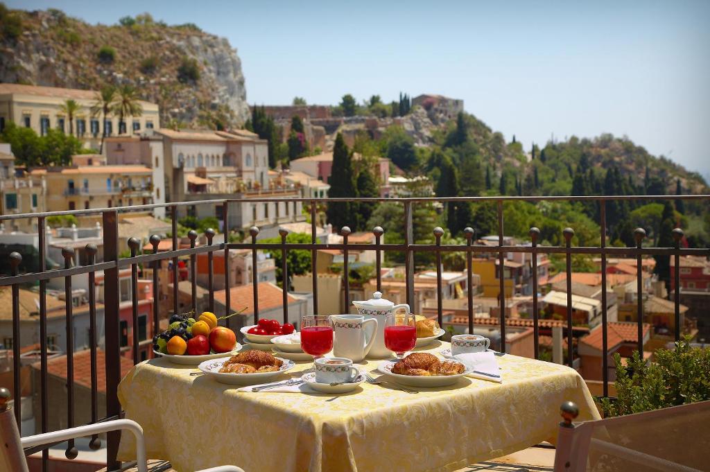 einen Tisch mit Teller mit Speisen auf dem Balkon in der Unterkunft Hotel Isabella in Taormina