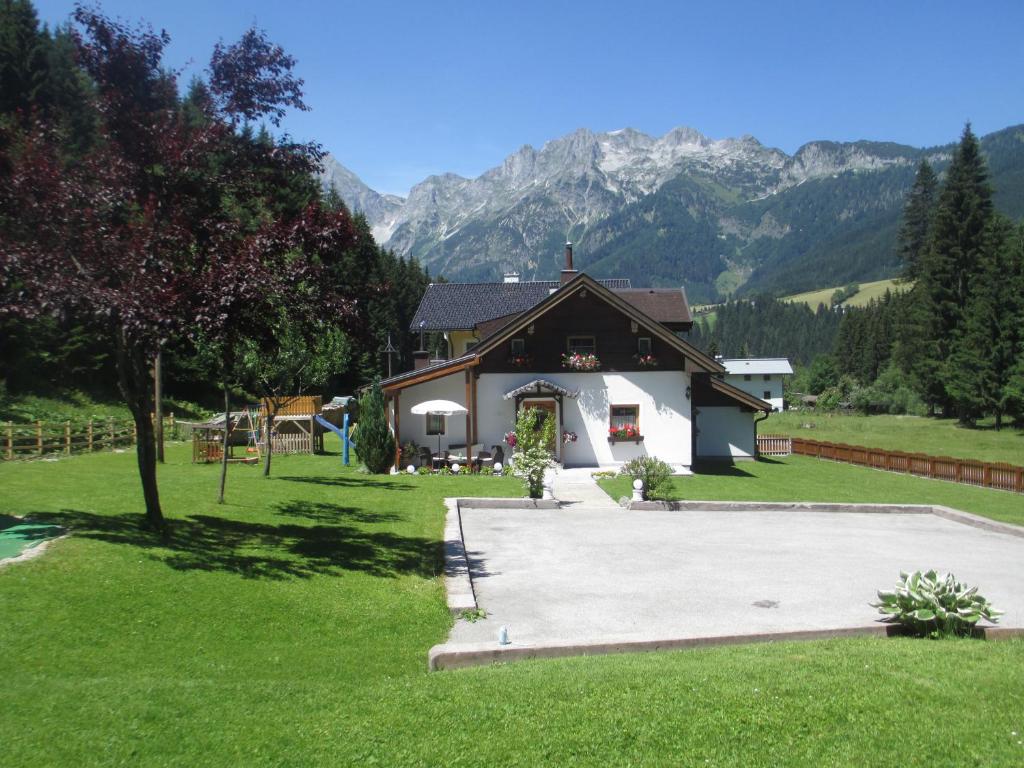 une maison dans un champ avec des montagnes en arrière-plan dans l'établissement Ferienhaus Schwarzenbacher, à Lungötz