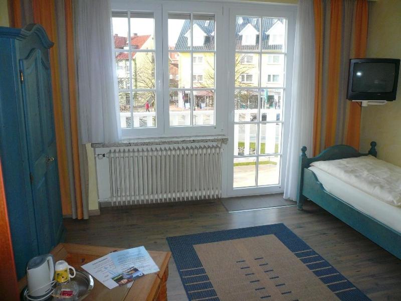 Schlafzimmer mit einem Bett, einem TV und einem Fenster in der Unterkunft Hotel-Restaurant Nord-Stuv in Cuxhaven