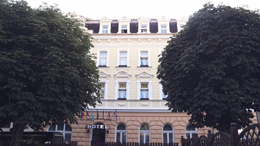 - un grand bâtiment blanc avec des fenêtres au-dessus dans l'établissement Hotel St.Michael, à Karlovy Vary