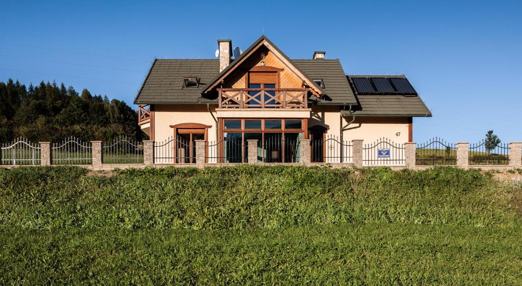 una casa in cima a una collina con una recinzione di Dom Na Stoku - Hillside Cottage Eliza a Szczawnica