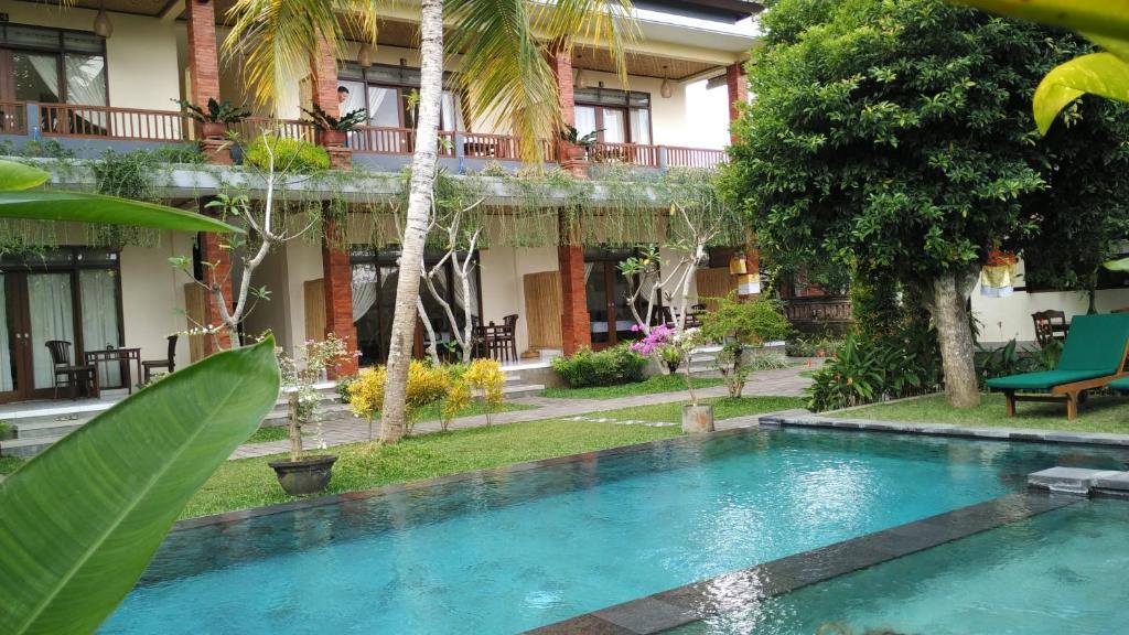 una piscina di fronte a un edificio di Nyoman Sandi Guest House ad Ubud