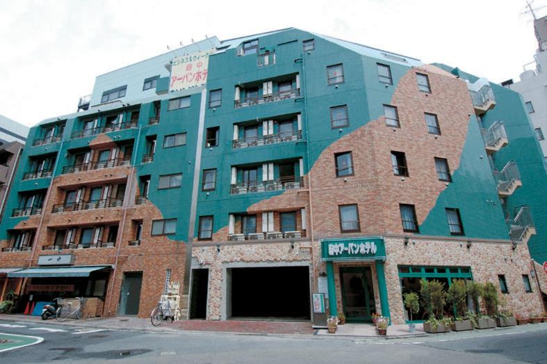 un grande edificio in mattoni su una strada cittadina di Fuchu Urban Hotel a Fuchū