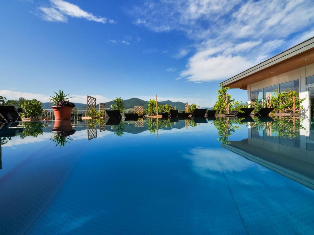 - une piscine d'eau bleue en face d'un bâtiment dans l'établissement Gartenhotel & Weingut Pfeffel Dürnstein, à Dürnstein