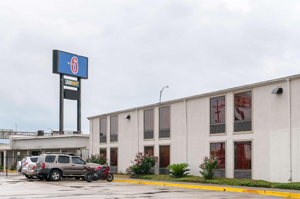 un bâtiment avec des voitures garées dans un parking dans l'établissement Motel 6-New Orleans, LA - Near Downtown, à La Nouvelle-Orléans