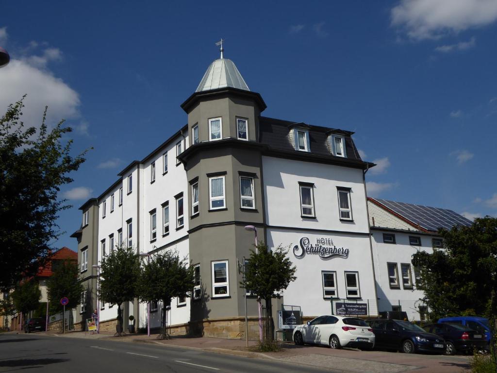 een groot wit gebouw met een klokkentoren op een straat bij Hotel am Schützenberg in Gotha